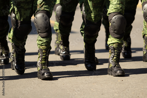 Tela close up of a group of military boots male soldiers at a parade, green camel mil
