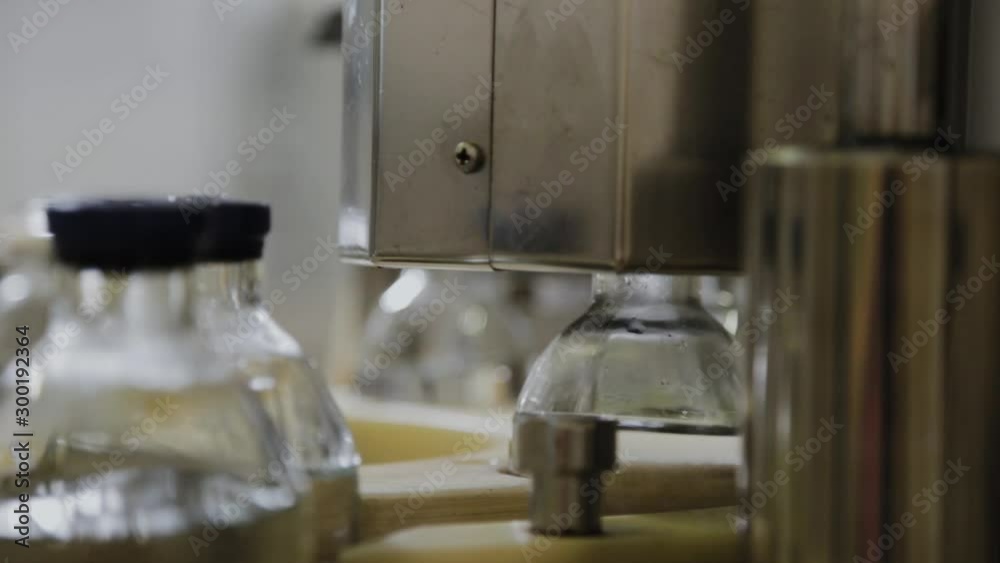 Pouring medicine on an assembly line into glass bottles for injection. Pouring medicine on an assembly line into glass bottles for injection.