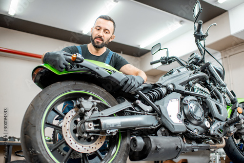 Worker repairing motorcycle in the workshop © rh2010