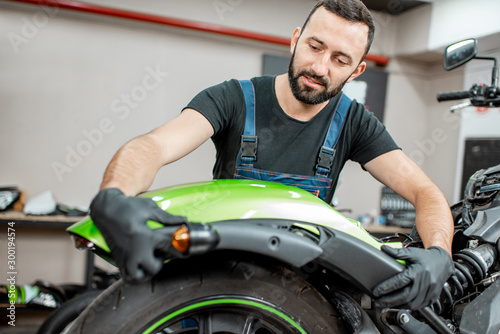 Worker repairing motorcycle in the workshop