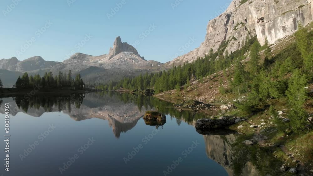 Drone aerial flying above mountain lake Lago Federa and pine forest near Croda da Lago ridge in Dolomites Italy at sunrise. Hiking nature epic landscape in South Tyrol. European Alps wanderlust. Drone aerial flying above mountain lake Lago Federa and pine forest near Croda da Lago ridge in Dolomites Italy at sunrise. Hiking nature epic landscape in South Tyrol. European Alps wanderlust.