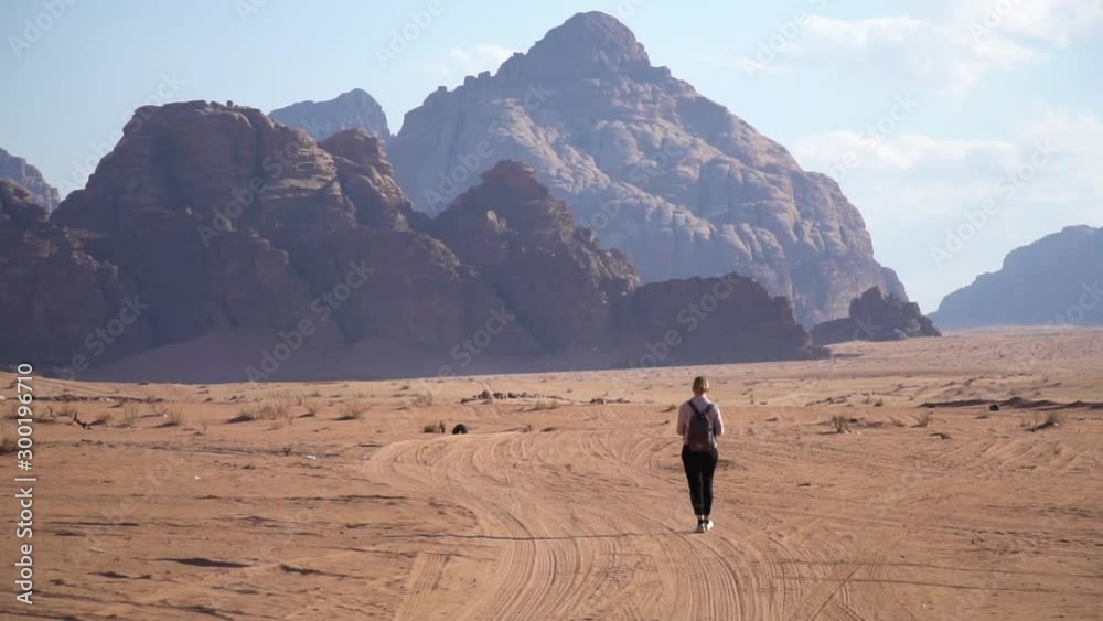 Woman walking in Wadi Rum desert, Jordan Woman walking in Wadi Rum desert, Jordan