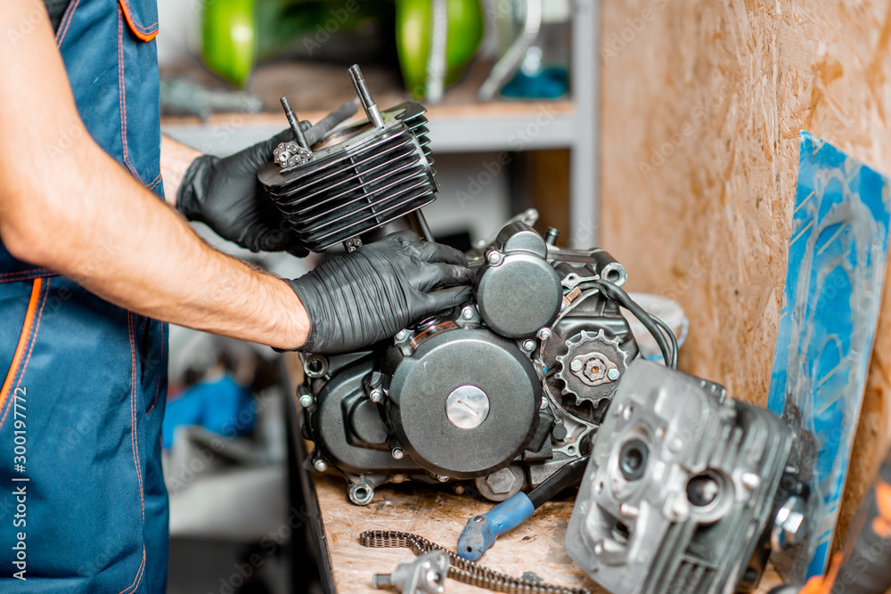 Obraz premium Man repairing motorcycle engine