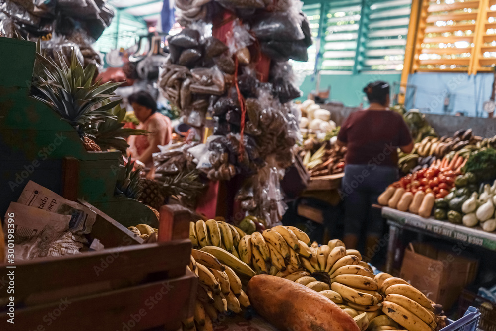 Organic tropical exotic fruits on display in a traditional market in Managua, Nicaragua. Food store. Bananas, cucumber, guavas, granadilla, tomatoes, passion fruit. Organic food. 