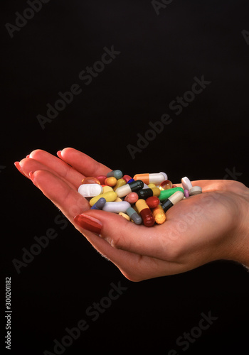 Female hand holding several pills