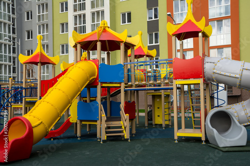 Wallpaper Mural Children's complex of different swings in the courtyard of a multi-storey building. Bright and safe game that can be played by children. Torontodigital.ca