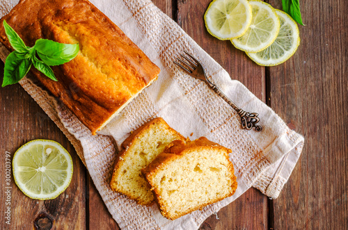 Lemon pound cake on rustic wooden background with lemon.