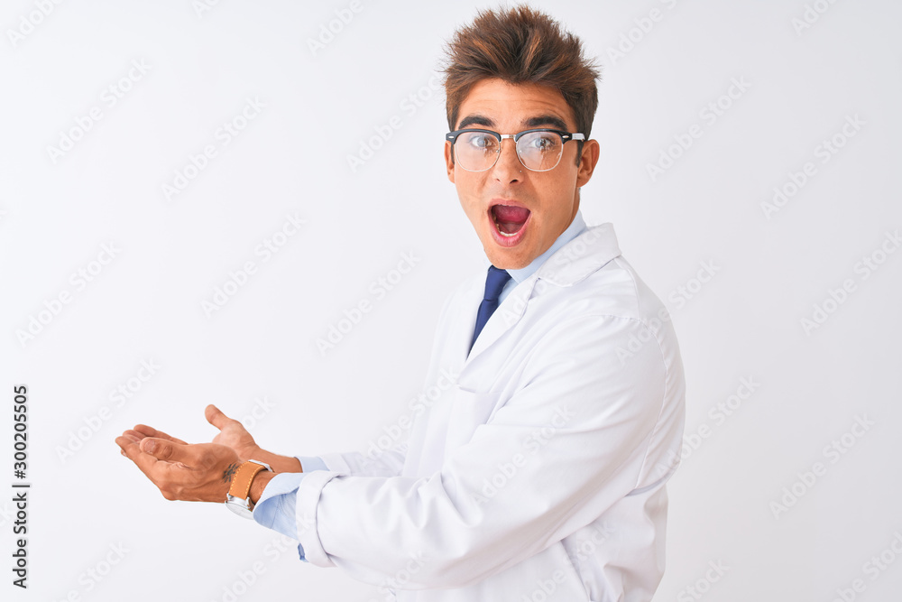Young handsome sciencist man wearing glasses and coat over isolated white background pointing aside with hands open palms showing copy space, presenting advertisement smiling excited happy Young handsome sciencist man wearing glasses and coat over isolated white background pointing aside with hands open palms showing copy space, presenting advertisement smiling excited happy