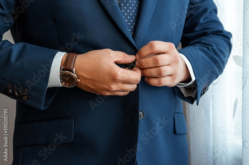 Hands of a businessman, close-up, buttons on a jacket. Concept of business style.