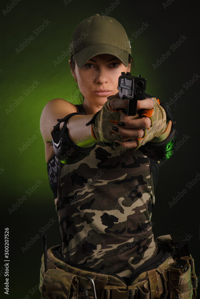 the girl in military overalls airsoft posing with a gun in his hands on a dark background in the haze the girl in military overalls airsoft posing with a gun in his hands on a dark background in the haze