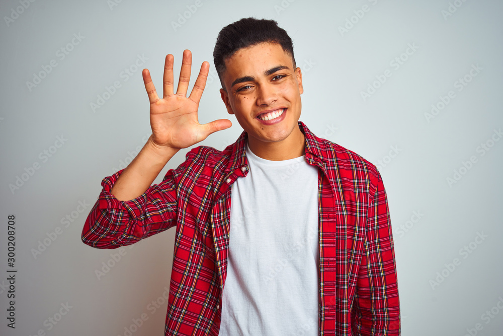 Young brazilian man wearing red shirt standing over isolated white background showing and pointing up with fingers number five while smiling confident and happy. Young brazilian man wearing red shirt standing over isolated white background showing and pointing up with fingers number five while smiling confident and happy.