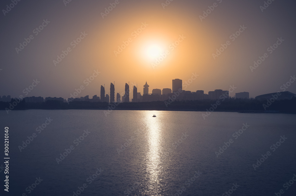 Shanghai sunset skyline from Century Park with lake and boat Shanghai sunset skyline from Century Park with lake and boat