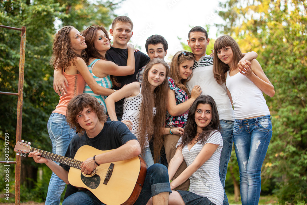 Obraz premium Cheerful teenagers playing guitar and singing 