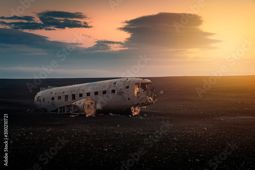 Obraz na płótnie Crushed plane Dakota on black beach at the sunset w salonie