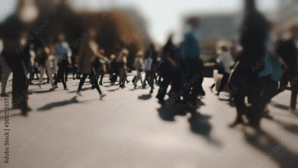 Pedestrians and shoppers commuting in the city on a busy bright day crossing the intersection. No logos trademarks or faces visible.10 bit original BMPCC clip.