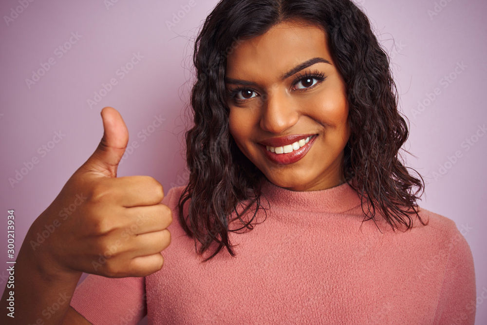 Young beautiful transsexual transgender woman standing over isolated pink background happy with big smile doing ok sign, thumb up with fingers, excellent sign Young beautiful transsexual transgender woman standing over isolated pink background happy with big smile doing ok sign, thumb up with fingers, excellent sign