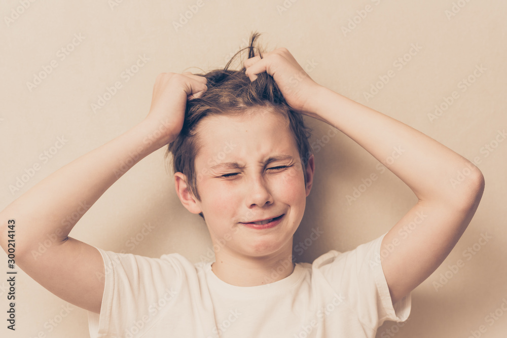 Frustrated boy is tearing his hair out. Frustration, depression, parenting problems concept Frustrated boy is tearing his hair out. Frustration, depression, parenting problems concept