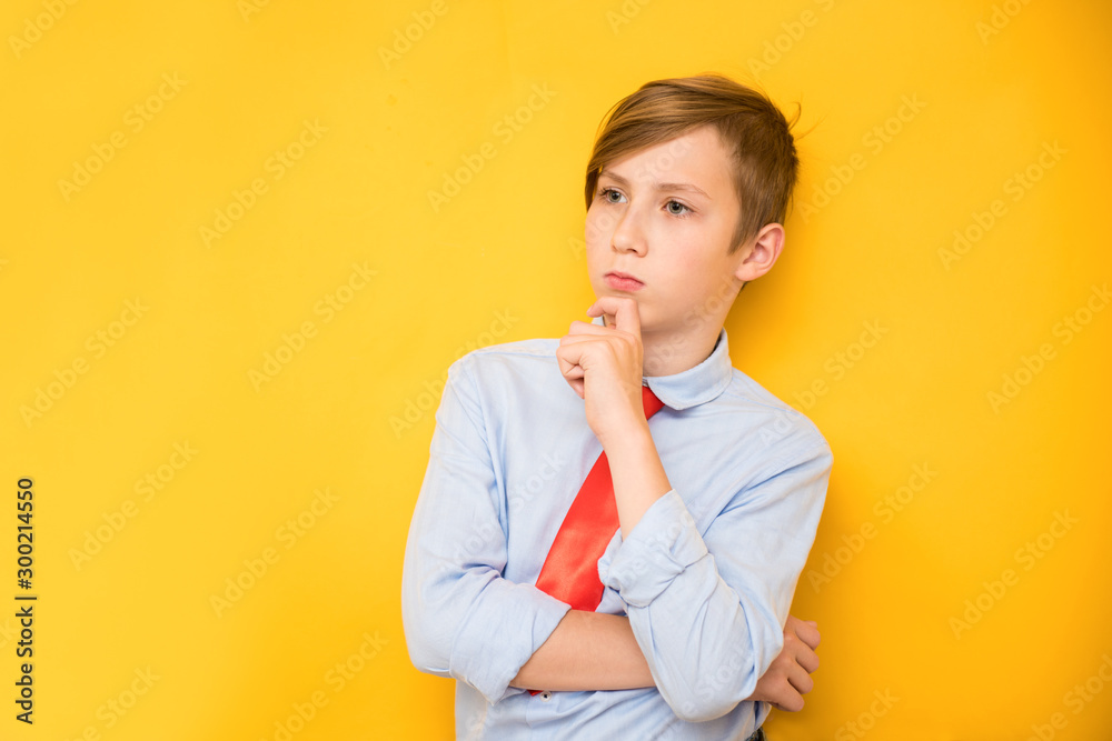 Portrait of young businessman of boy in a shirt. Successful teenager on a yellow background Portrait of young businessman of boy in a shirt. Successful teenager on a yellow background