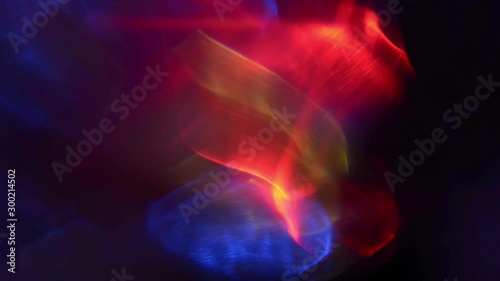 Colorful holographic abstract images projections in black empty room.