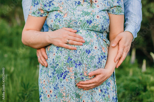 Maternity photo of a pregnant woman holding her baby bump belly