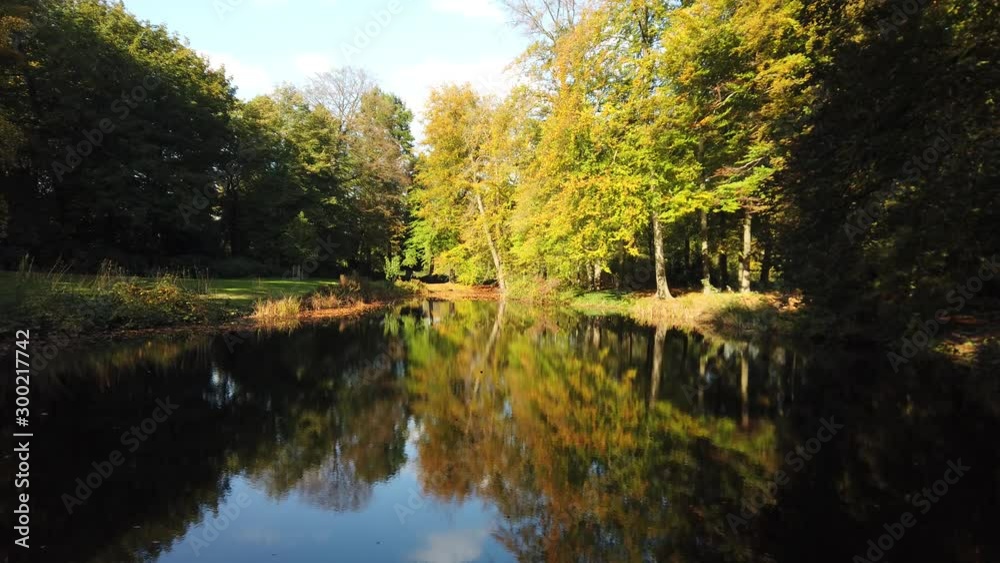 Autumn forest lake with tree reflections in the water Autumn forest lake with tree reflections in the water