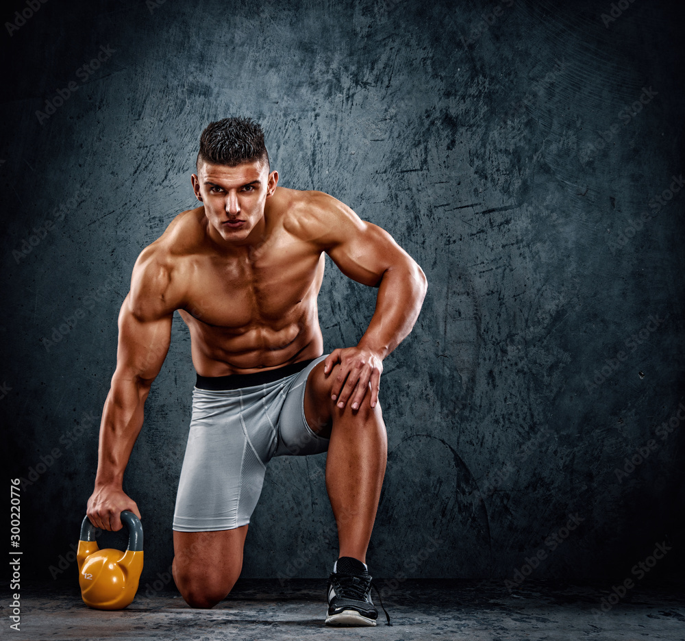 Fototapeta premium Handsome Muscular Men Exercise With Kettlebell. Cross training athlete