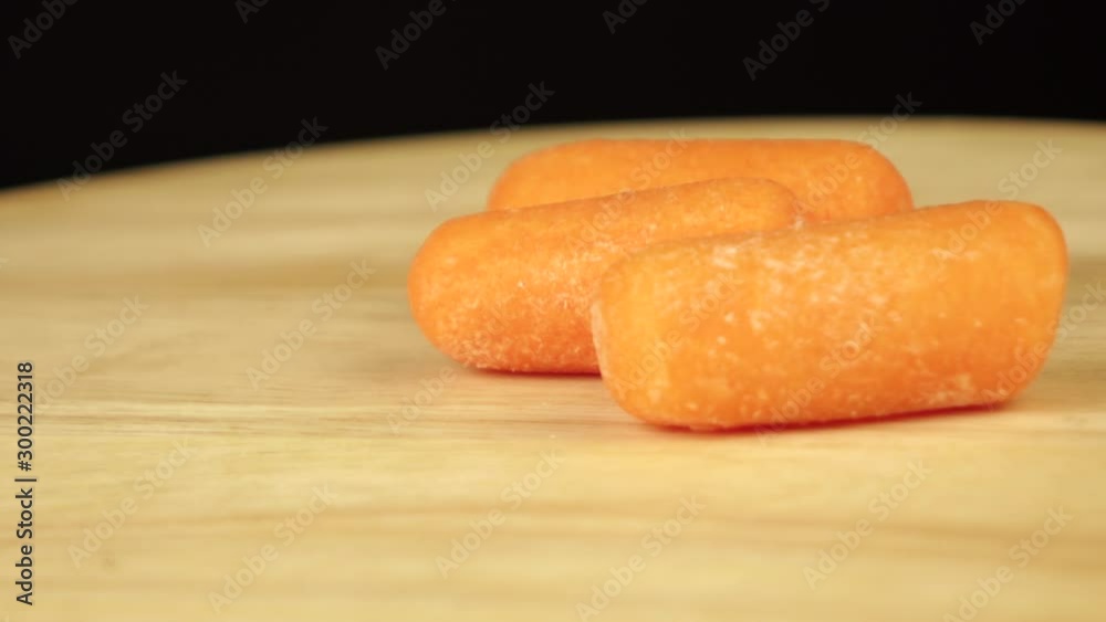 lots of little carrots rotate 360 degrees on a wooden platform lots of little carrots rotate 360 degrees on a wooden platform