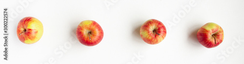 Banner flat lay top view of four red apples on white background. Food concept