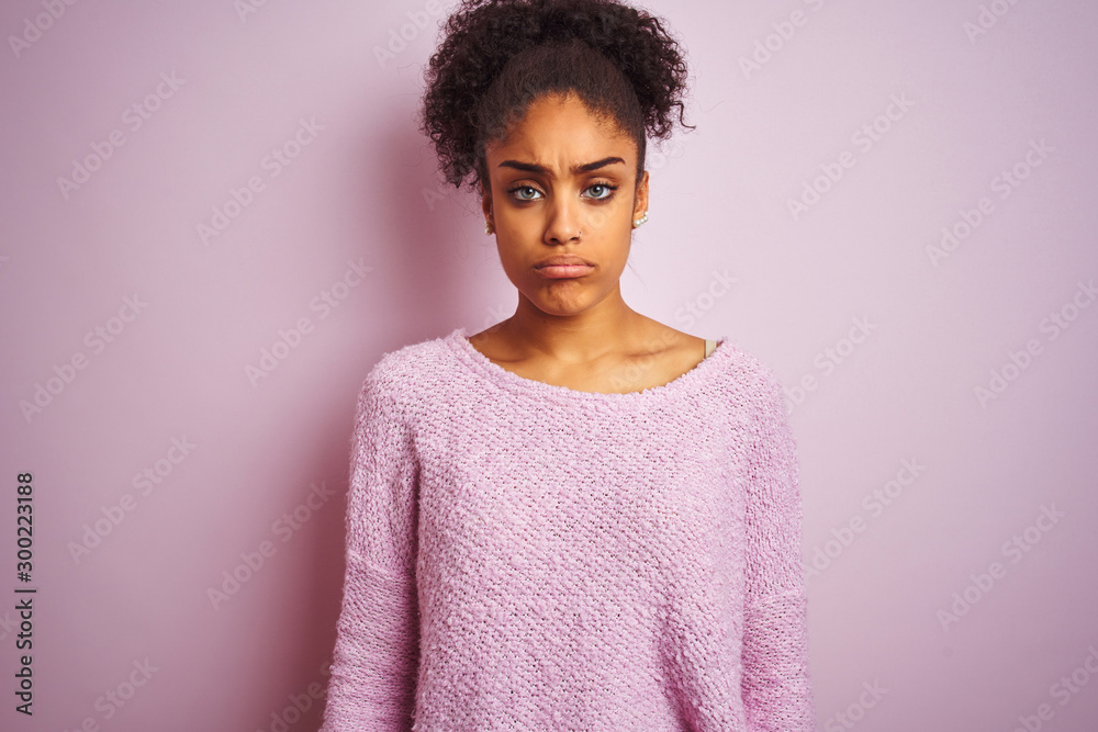 Young african american woman wearing winter sweater standing over isolated pink background depressed and worry for distress, crying angry and afraid. Sad expression. Young african american woman wearing winter sweater standing over isolated pink background depressed and worry for distress, crying angry and afraid. Sad expression.