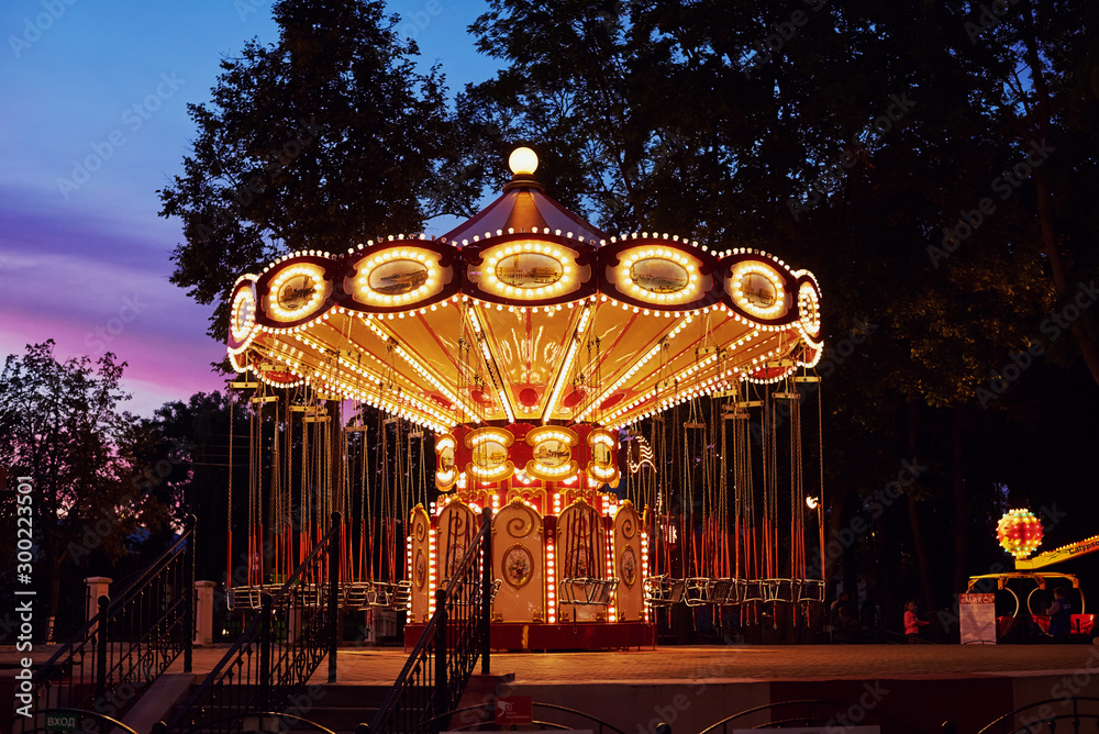 Obraz premium Carousel Merry go round in amusement park at evening city