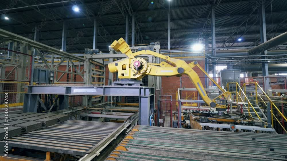 Modern factory machine moves bricks from a conveyor in a facility. Modern factory machine moves bricks from a conveyor in a facility.