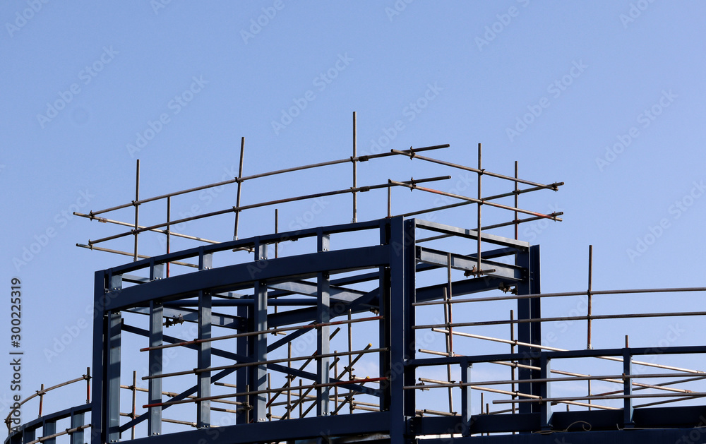 Building site girders and scaffolding against a blue sky