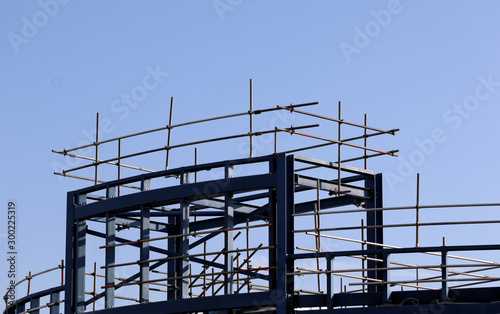 Building site girders and scaffolding against a blue sky