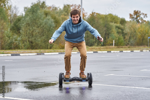 Man riding on the hoverboard and using smartphone outdoor photo