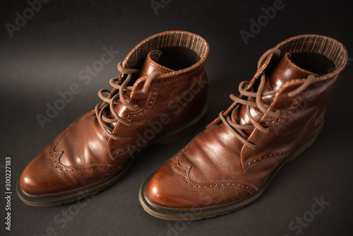 Vintage brown boots on black background, retro shoes