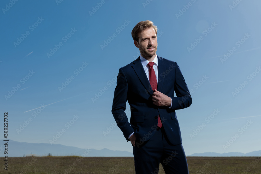 Hopeful businessman looking away with his hand in his pocket Hopeful businessman looking away with his hand in his pocket