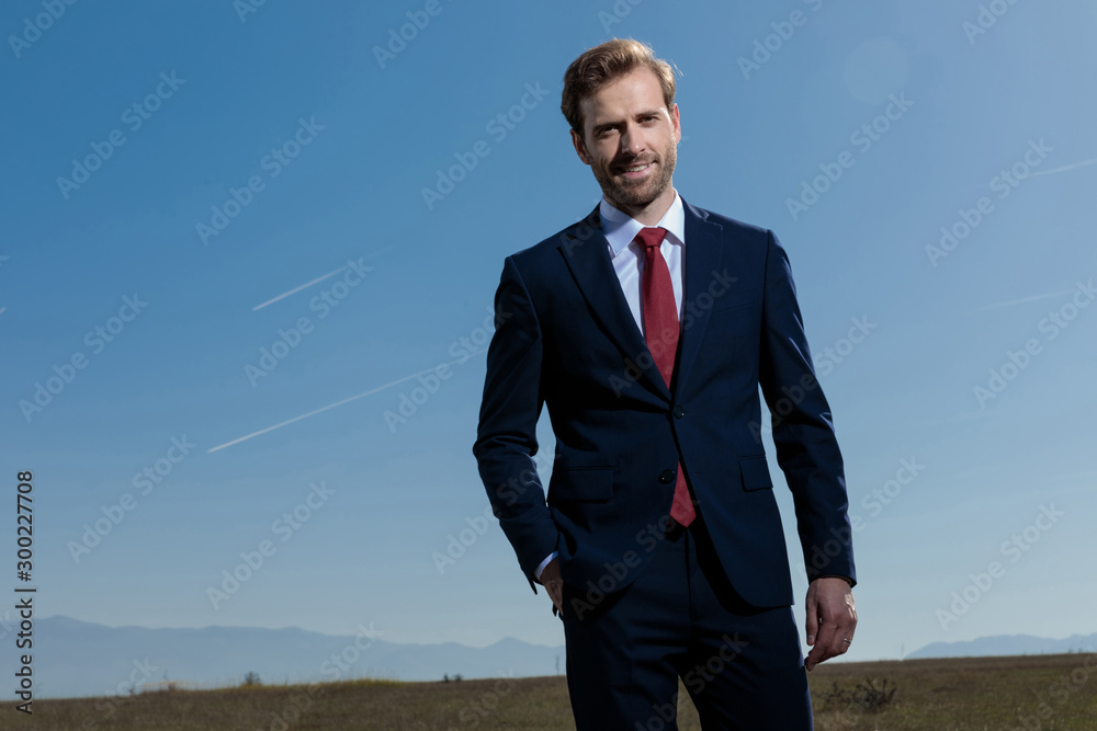 Confident businessman holding his hand in his pocket and smiling Confident businessman holding his hand in his pocket and smiling