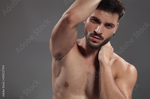 dramatic naked cool guy holding hand to neck and hair