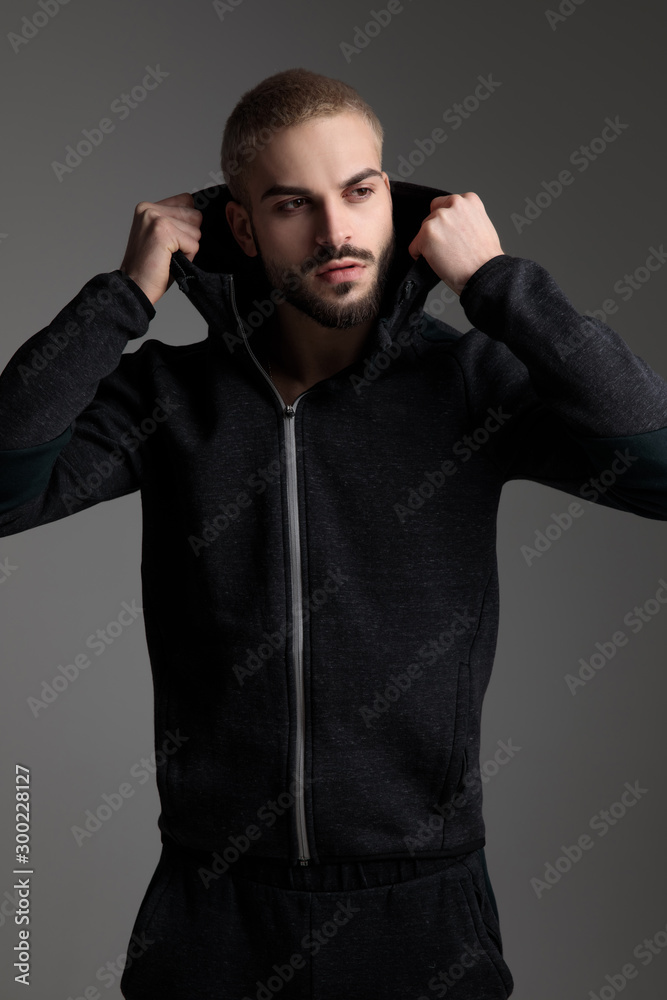 Obraz premium casual man fixing hood and looking away serious