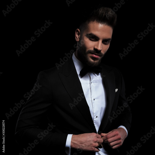 businessman wearing black tuxedo standing and opening his jacket photo