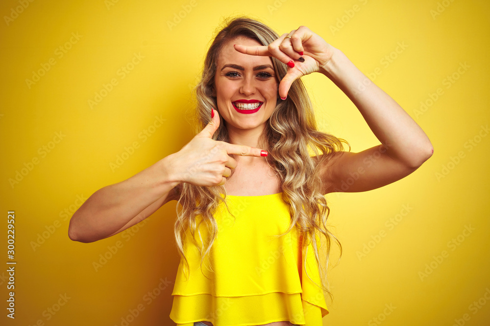 Young attactive woman wearing t-shirt standing over yellow isolated background smiling making frame with hands and fingers with happy face. Creativity and photography concept. Young attactive woman wearing t-shirt standing over yellow isolated background smiling making frame with hands and fingers with happy face. Creativity and photography concept.