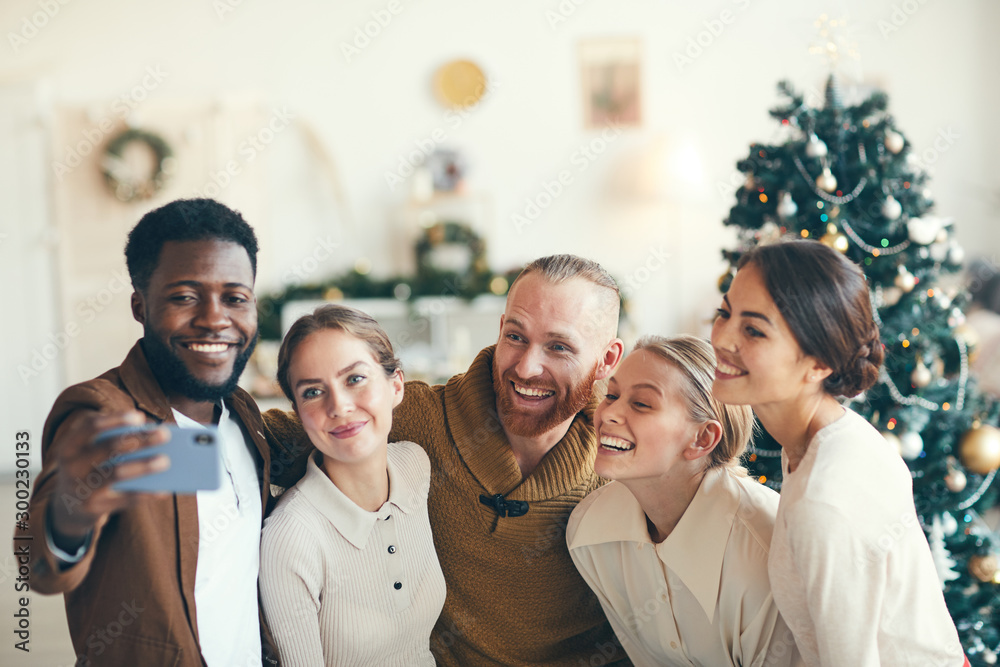 Group of elegant adult people smiling at camera while taking selfie photo during Christmas party, copy space Group of elegant adult people smiling at camera while taking selfie photo during Christmas party, copy space