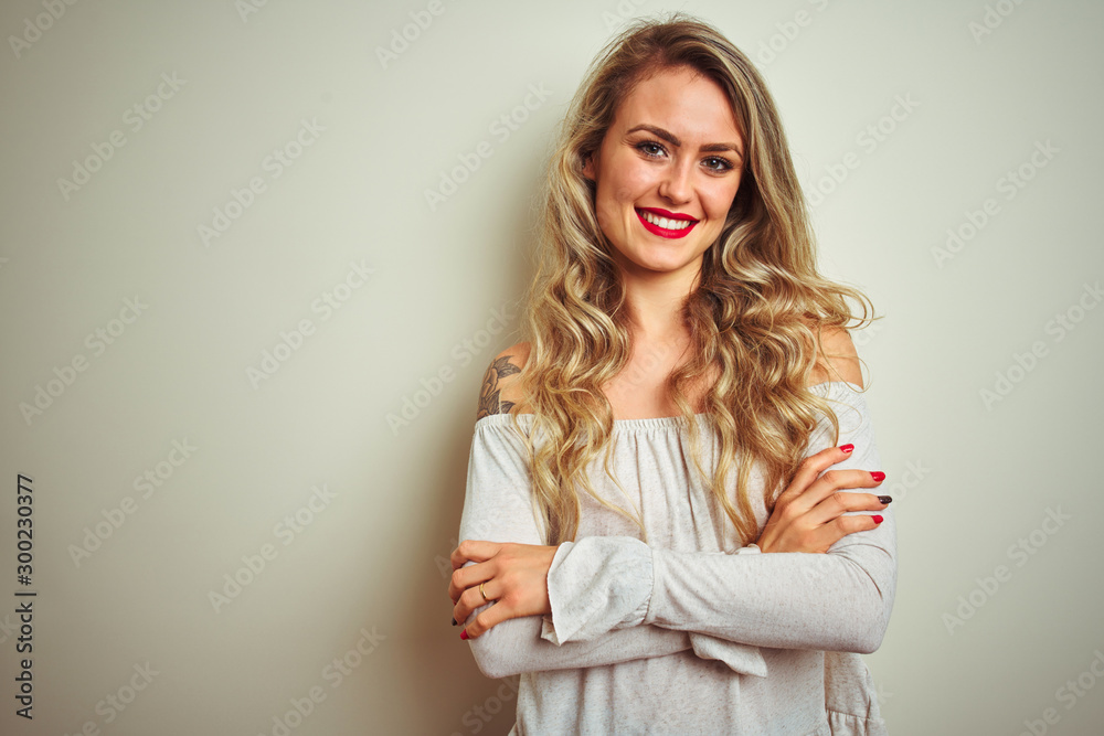 Young beautiful woman standing over white isolated background happy face smiling with crossed arms looking at the camera. Positive person. Young beautiful woman standing over white isolated background happy face smiling with crossed arms looking at the camera. Positive person.