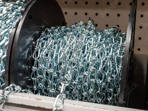 Roll of steel chain sitting in indoors storage area rolled up photo