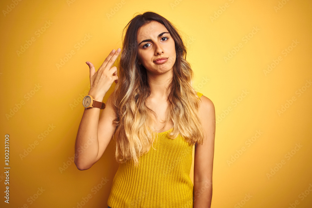 Young beautiful woman wearing t-shirt over yellow isolated background Shooting and killing oneself pointing hand and fingers to head like gun, suicide gesture. Young beautiful woman wearing t-shirt over yellow isolated background Shooting and killing oneself pointing hand and fingers to head like gun, suicide gesture.