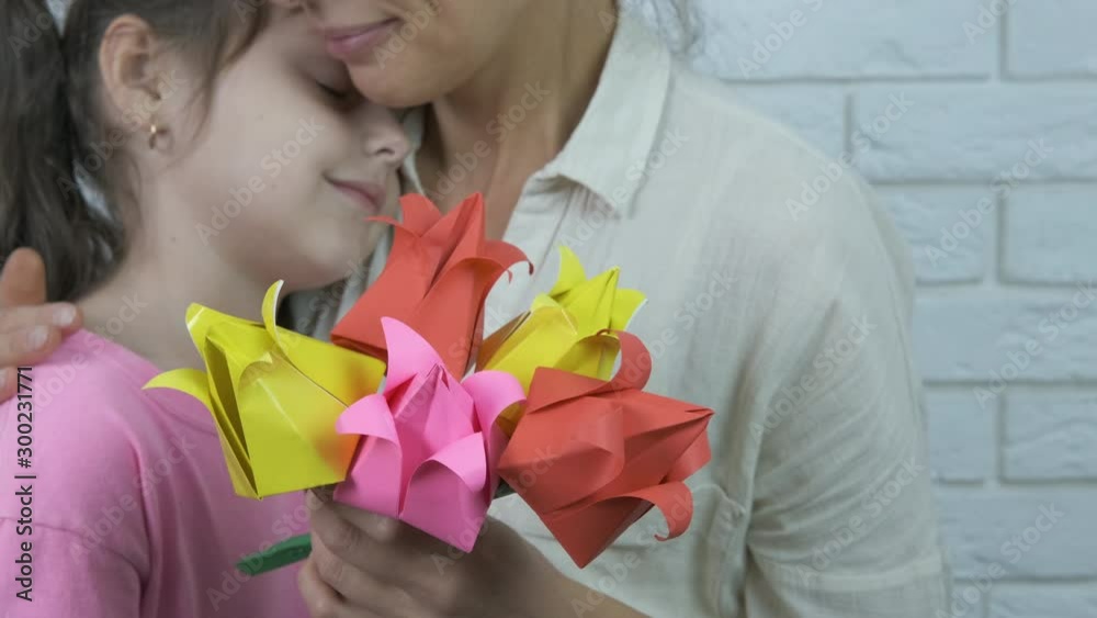 A gift for mother. Cute little girl with mom with paper flowers. A gift for mother. Cute little girl with mom with paper flowers.