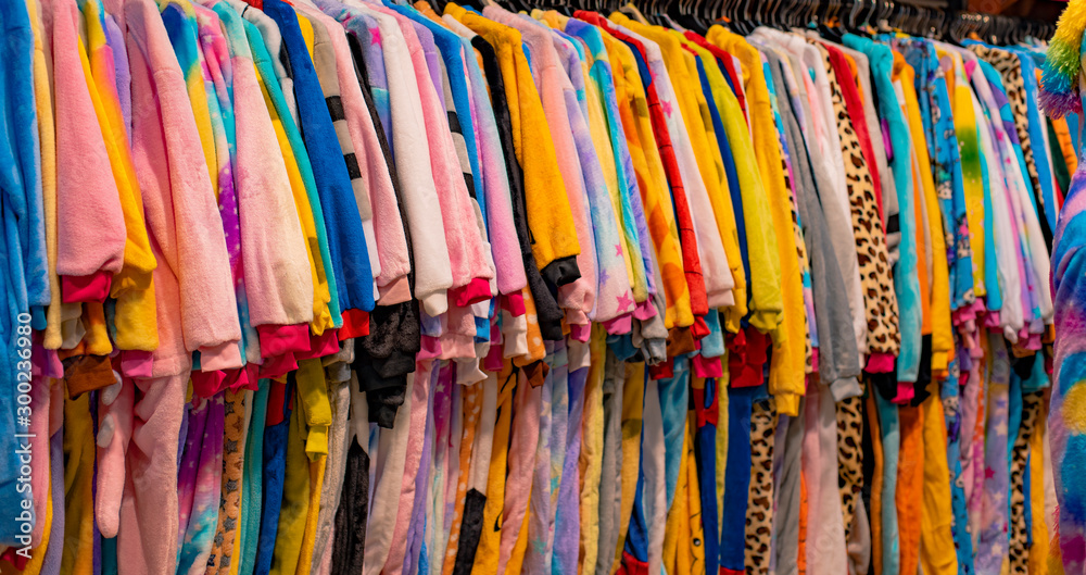 kigurumi pajamas in shop counter rack for selling colorful fabric clothes  background 