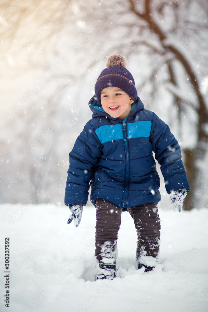 Adorable, cute boy playing with snow cheerfully Adorable, cute boy playing with snow cheerfully
