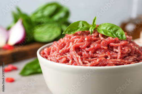 Fresh raw minced meat on light table, closeup