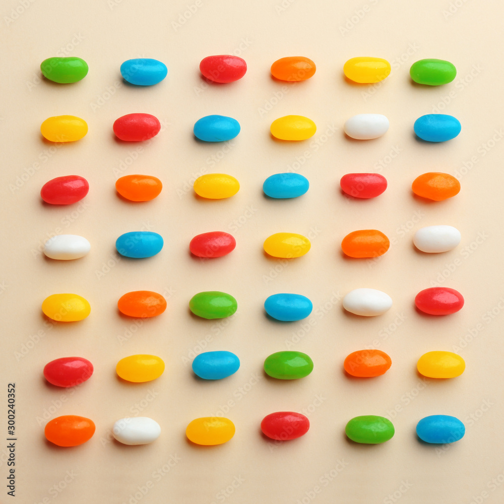 Colorful jelly beans on beige background, flat lay Colorful jelly beans on beige background, flat lay